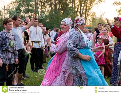 Two Women In Colorful Russian Costumes Dancing For The Time Of The