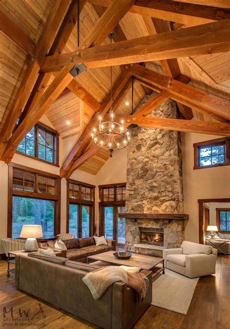 Large formal living room with a nice set of seats, beige walls and a ceiling with exposed beams, lighted by a gorgeous ceiling lighting. Martis Camp, Tahoe lodge, stone fireplace, heavy timber ...