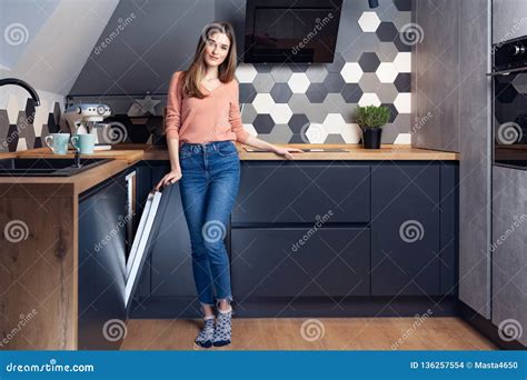 Beautiful Young Smiling Woman Doing Dishes In The Kitchen Stock Photo
