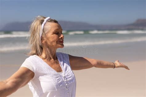 Side View Of Senior Woman Standing With Arms Outstretched At Beach Stock Image Image Of