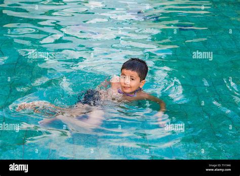 A Young Boy Smiling Swimming And Having Fun In Pool At Waterpark Stock