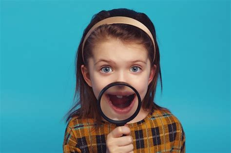 Premium Photo Excited Girl Show Her Teeth Through Magnifying Glass