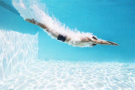 Man Diving Into Swimming Pool Stock Photo