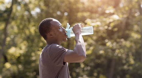 Overheated Black Guy Drinking Water From Bottle In Park Regional One