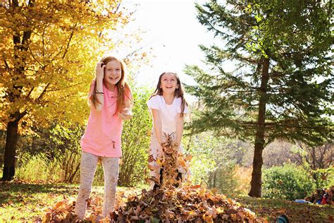 Two Young Girls Playing Outside In Fall Leaves Photograph By Cavan