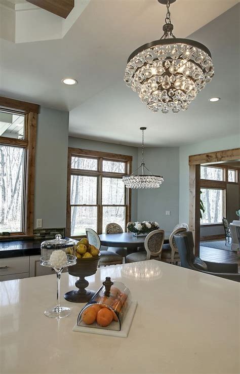 A Kitchen With A Chandelier Hanging Over Its Counter Top Next To A