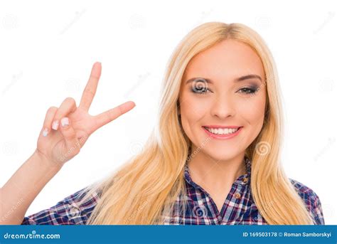 Portrait Of Cheerful Young Blonde Gesturing With Two Fingers Stock