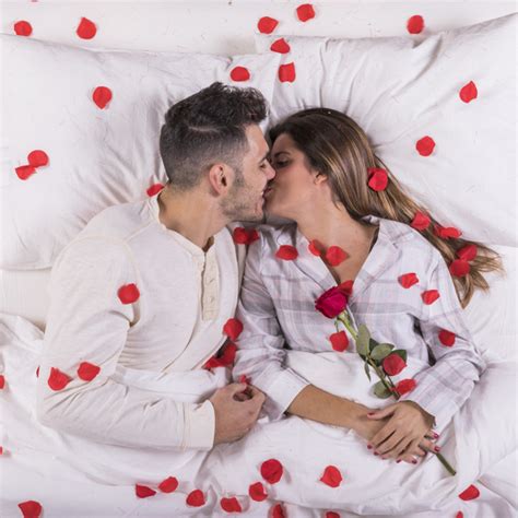 Couple Sembrassant Au Lit Avec Des Pétales De Rose Photo Gratuite