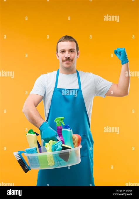 Happy Janitor Holding Cleaning Supplies And Showing His Arm Muscles