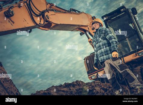 Excavator Operator at Work. Professional Ground Works Contractor and
