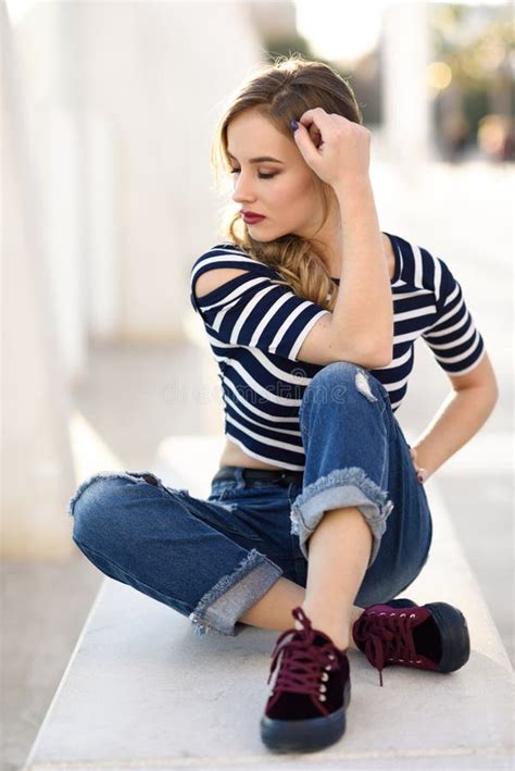 Blonde Woman Model Of Fashion Sitting In Urban Background Stock