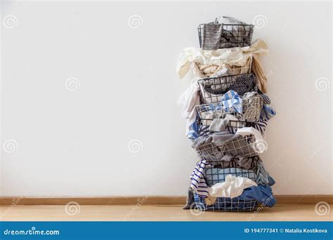 One Row Of Stacked Metal Laundry Basket With Full Of Clothing On White