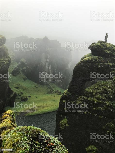 Woman Standind On Cliff Overgrown With Green Moss Surrounded By A Very