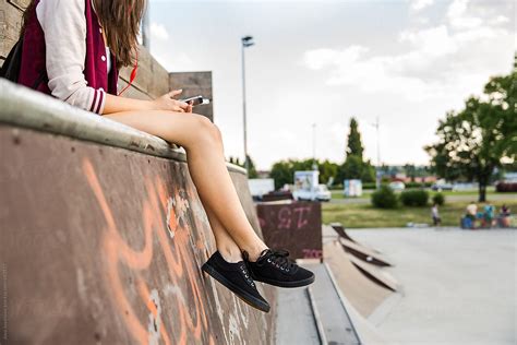Woman Checking Her Phone Sitting In A Skate Park By Stocksy Contributor Jovo Jovanovic Stocksy