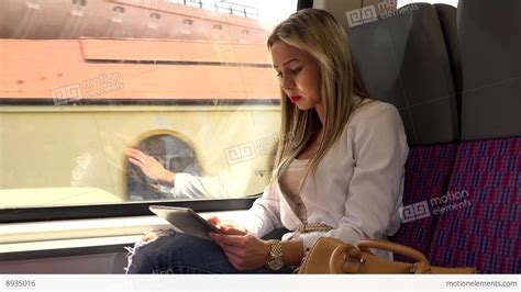 Young Attractive Blonde Woman Traveling By Train And Works On Tablet