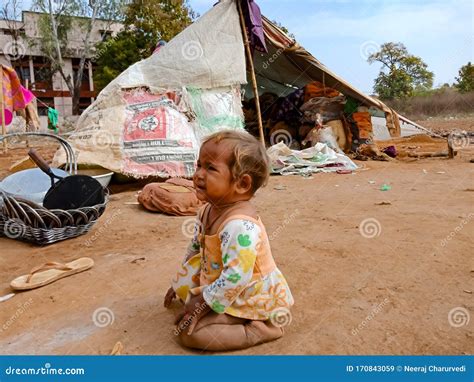 An Indian Cute Little Poor Kid Girl Crying Outside The Huts At Soil