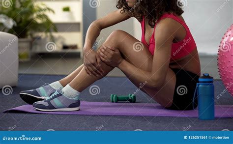 Girl In Gym Outfit Sitting On Floor And Massaging Cramped Leg Strained