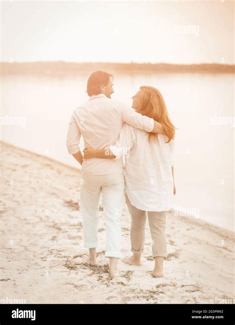 Adult Couple Barefoot Walks Hugging Seashore Stock Photo Alamy