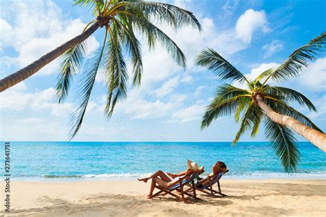 Couple Relax On The Beach Enjoying Beautiful Sea On The Tropical Island