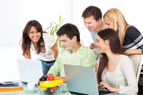Group Of Young Happy People Working On Laptop Computer Stock Photo