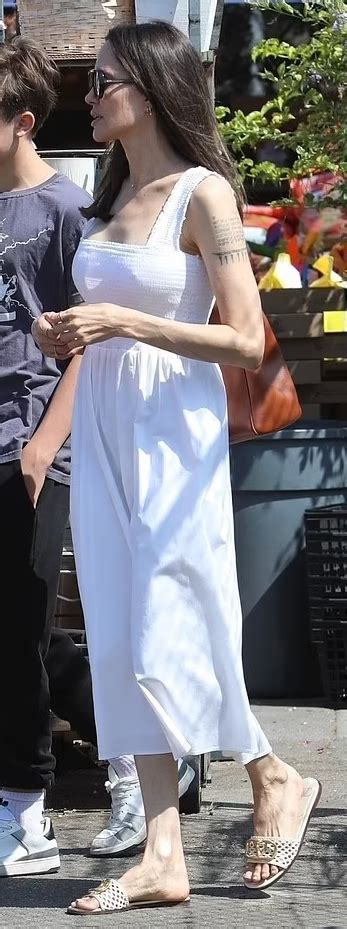 Who Made Angelina Jolies Black Sunglasses And Slide Sandals Outfitid