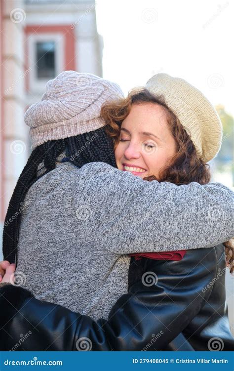 two multiracial female happy friends hugging each other on city street stock image image of