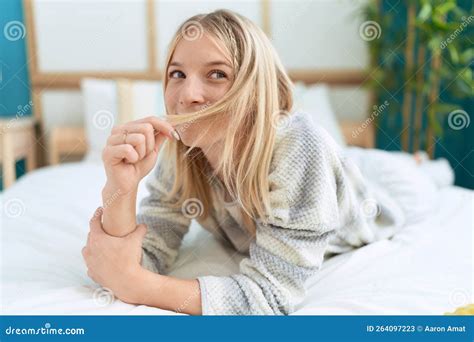 Young Blonde Woman Smiling Confident Lying On Bed At Bedroom Stock