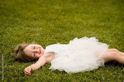 Little Girl Lying On Grass Lawn Smiling Stock Photo Adobe Stock