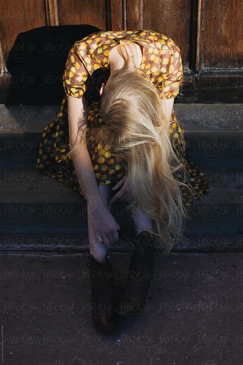 beautiful girl in vintage dress sitting by an old door del colaborador de stocksy gabrielle