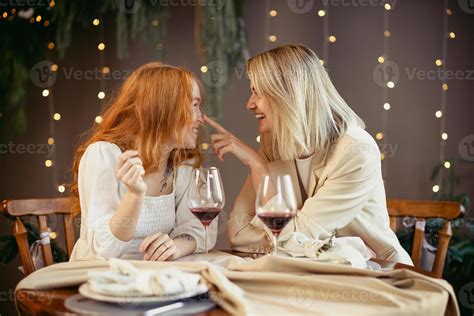 Lesbian Couple Having Dinner In A Restaurant Girls Drink Wine And Talk Stock Photo At