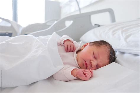 First Days Of A Newborn Baby Girl Sleeping In Hospital Room By