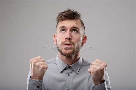 Young Man Clenching Fists In Winning Gesture Stock Photo Image Of