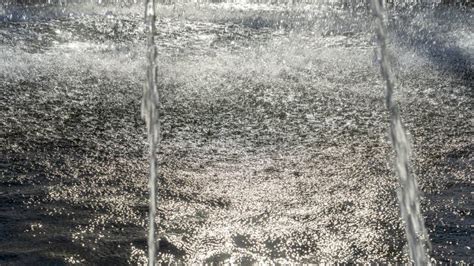 Close Up View Of Streams Of Fountain With Reflection And Lens Flare