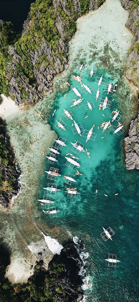 Aerial Photography Of Boats Beside Mountain During Iphone X