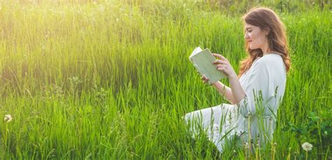 hermosa chica en campo leyendo un libro la niña sentada en el césped leyendo un libro