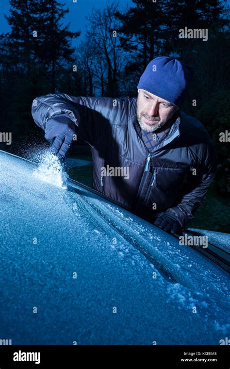A Man Scraping Ice From A Car Windscreen Stock Photo Alamy
