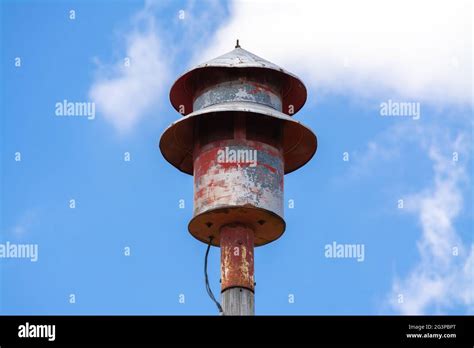 Old Tornado Siren In Small Midwest Town With Blue Skies And Clouds In