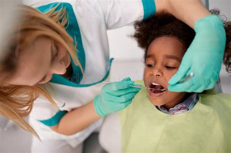 Babies usually start getting teeth around 6 months of age and cavities can develop as quickly as teeth appear,1 so consider getting dental insurance as early as possible. Female Dentist Repair Tooth To Black Child Stock Image ...