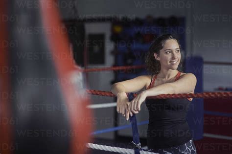 Young Female Boxer Leaning On Boxing Ring Ropes Stock Photo