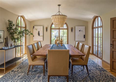 A Dining Room Table With Chairs And A Chandelier