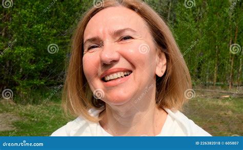 positive beautiful mature woman face mid adult lady smiling outdoors portrait of female age 55