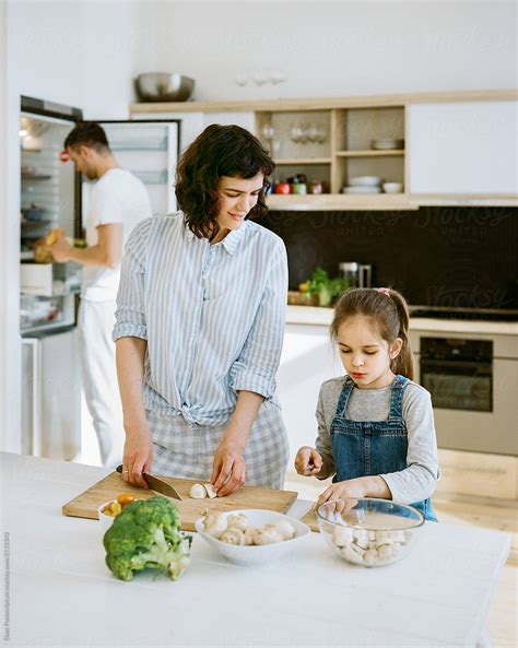 Daughter Helping Mother In Kitchen By Stocksy Contributor Duet