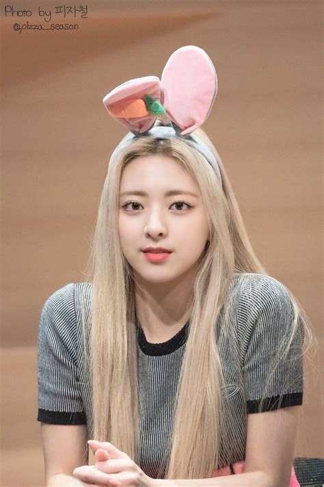 A Woman With Long Blonde Hair And Bunny Ears On Her Head Sitting At A Table
