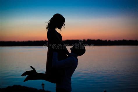 Silhouettes In Love Romantic Couple Lovers Hugging Kissing Touching Eye Contact At Sunset