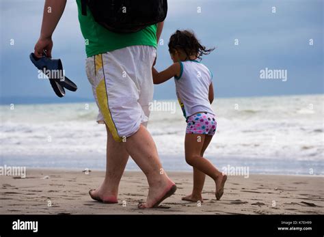 Padre E Hija Tomados De Las Manos Mientras Camina En La Playa