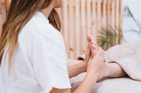 Woman Receiving Foot Massage Service From Masseuse Close Up At Hand And Foot Relax In Foot