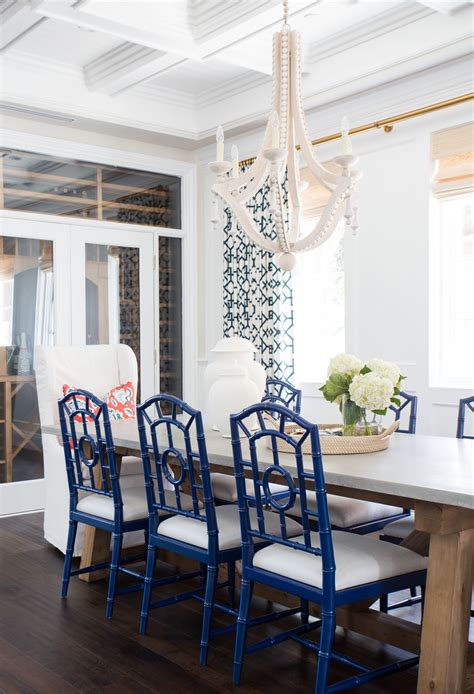 Stunning dining room with visual comfort lighting 6 light marigot chandelier in antique burnished brass over rectangular dining table lined with navy blue dining chairs. Coastal Prep in the Pacific Palisades: Entry and Formal Living Tour | Coastal dining room ...