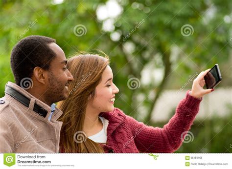 Pares Jovenes Interraciales Felices Hermosos Y Sonrientes En El Parl Que Toma Un Selfie Foto De
