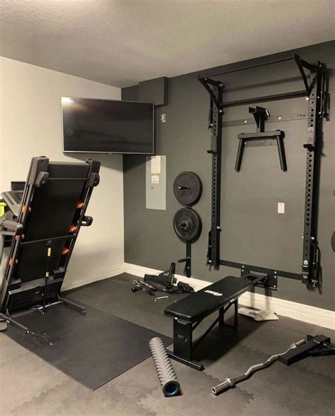 A Home Gym Is Shown With Equipment In The Corner And On The Wall As