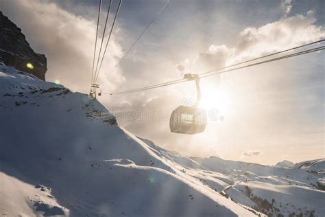 Gondola Lift Over Beautiful Snow Covered Mountains Against Bright Sun Stock Photo Image Of